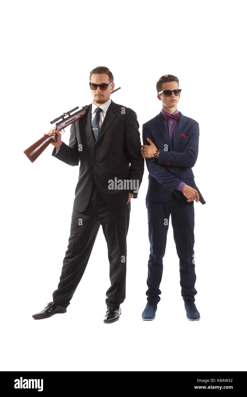 Zwei Männer in schicken Anzügen und Krawatten bewaffnet mit Gewehren. Stockfoto