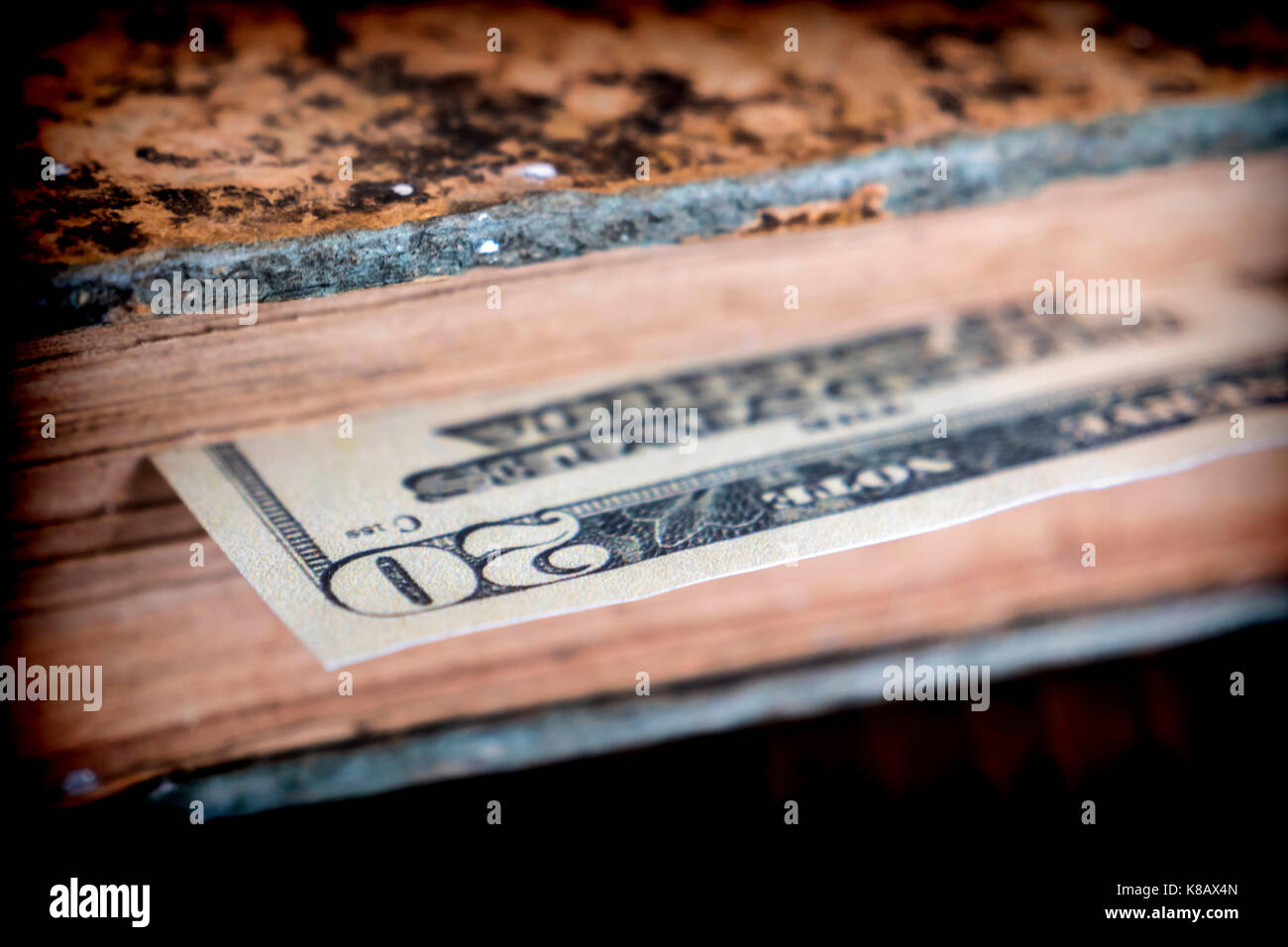 Bill von hundert amerikanische Dollar in einem alten Buch versteckt Stockfoto