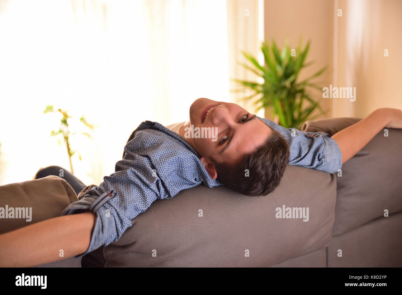 Man Liegeposition bequem auf dem Sofa im Wohnzimmer. Begriff der Freiheit Komfort und Ruhe. Ansicht von hinten Stockfoto