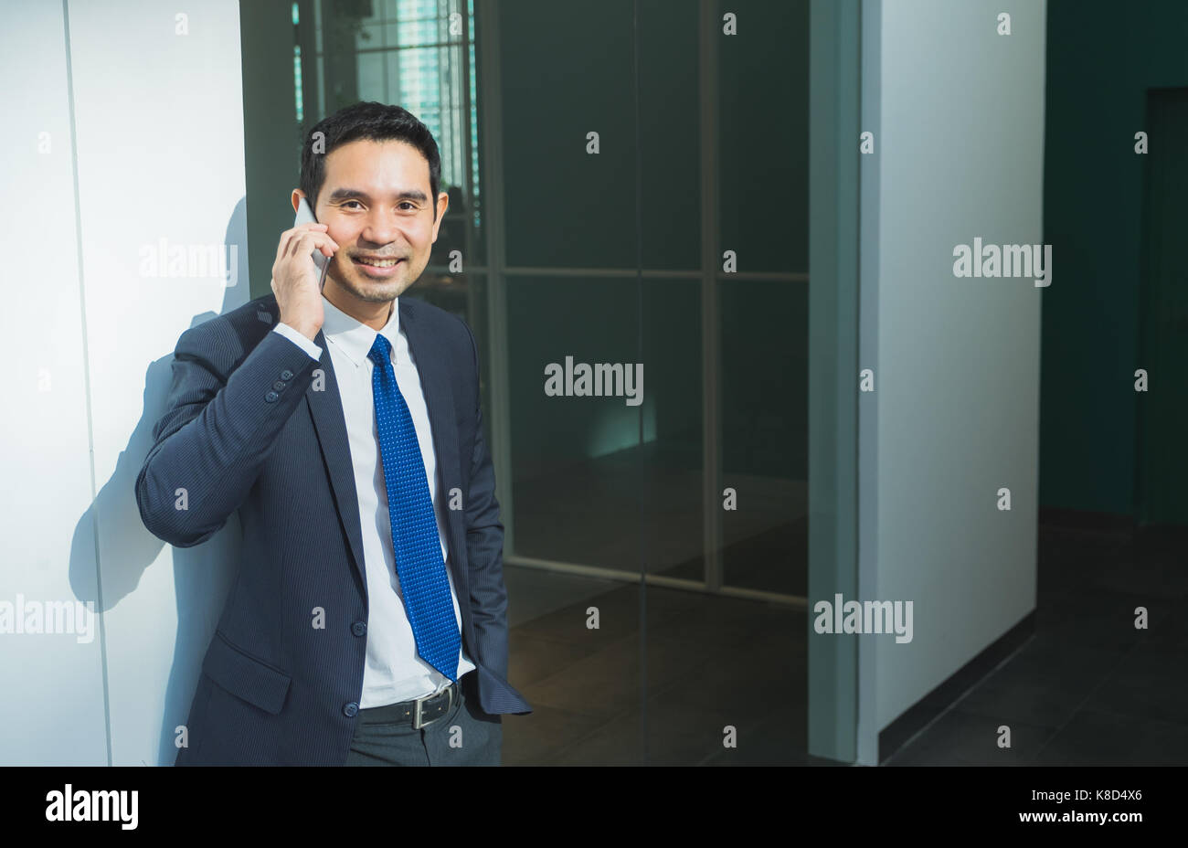 Geschäftsmann mit Mobiltelefon indise Bürogebäude, nach der Arbeit, Büro Lifestyle. Stockfoto