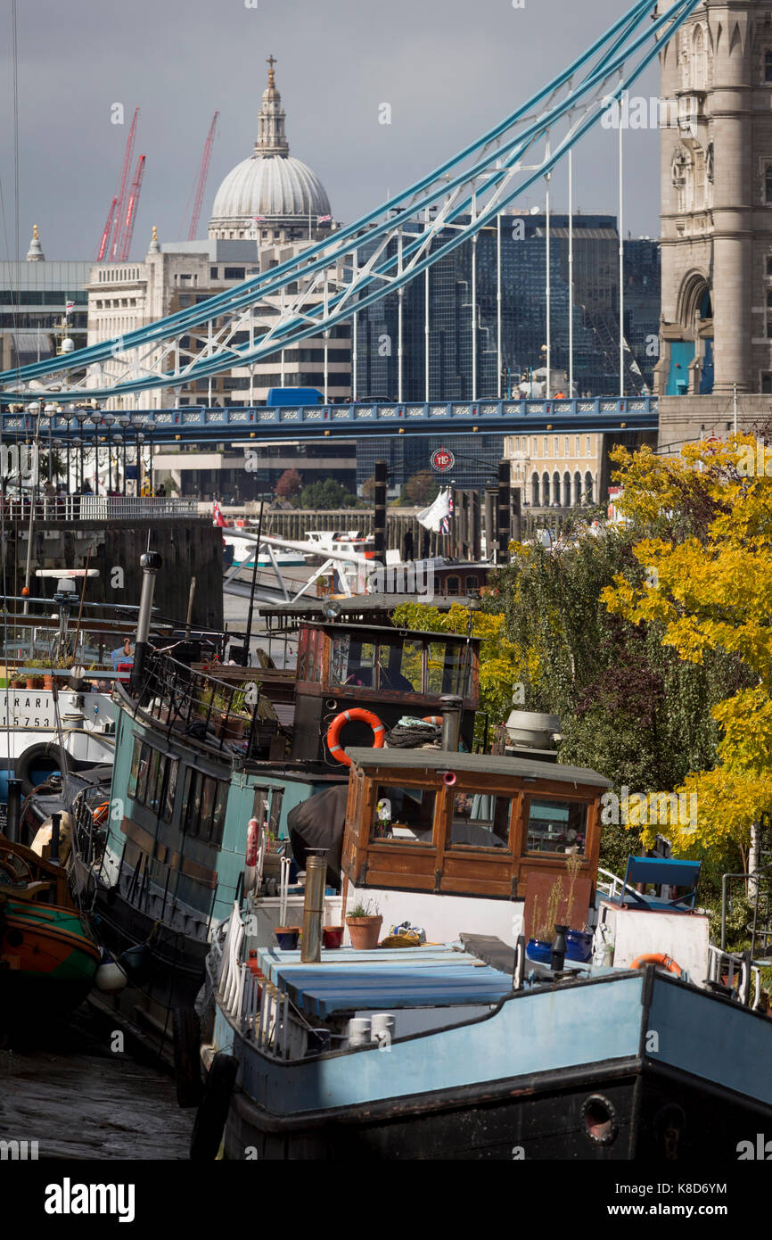 Mit der Kuppel der St. Paul's Cathedral im Süden Federung Ketten von der Tower Bridge in der Ferne, privat geführte Boote vieler Arten in der Ebbe Schlamm auf der Themse am Fluss Gemeinschaft Tower Bridge Moorings, am 14. September 2017 in London, England sitzen. Stockfoto