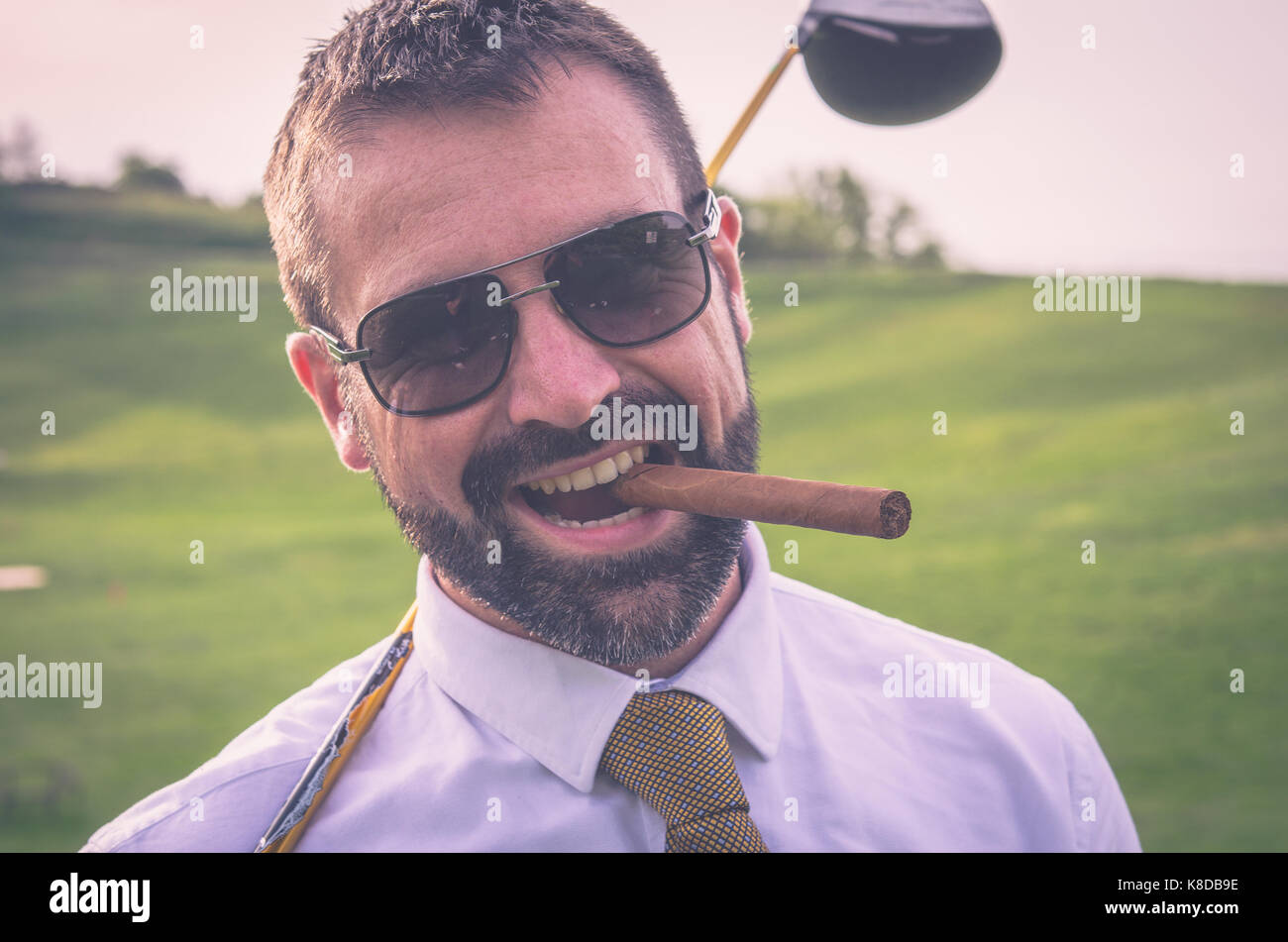 Portrait von lächelnden Golfspieler mit Zigarre mit Fahrer Stockfoto