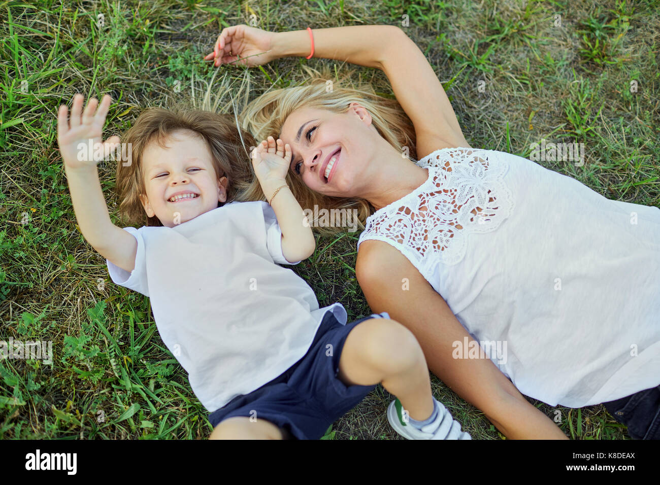 Mutter und Sohn umarmen Spielen auf dem Rasen im Park. Stockfoto