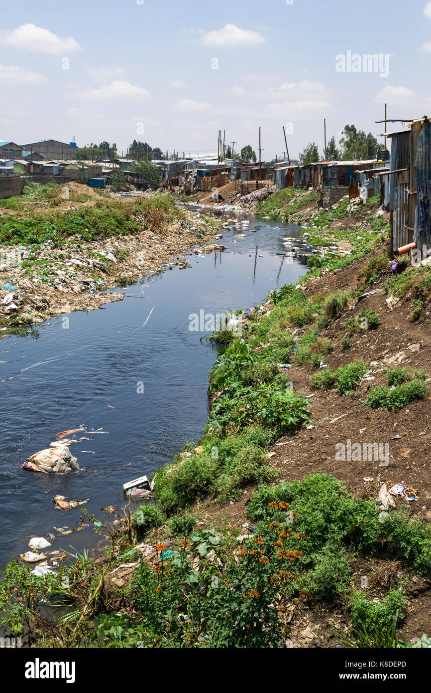 Slum Baracken und Gebäuden die Ngong Fluss, der mit Müll, Plastik Abfall und Müll verschmutzt ist, Nairobi, Kenia Stockfoto