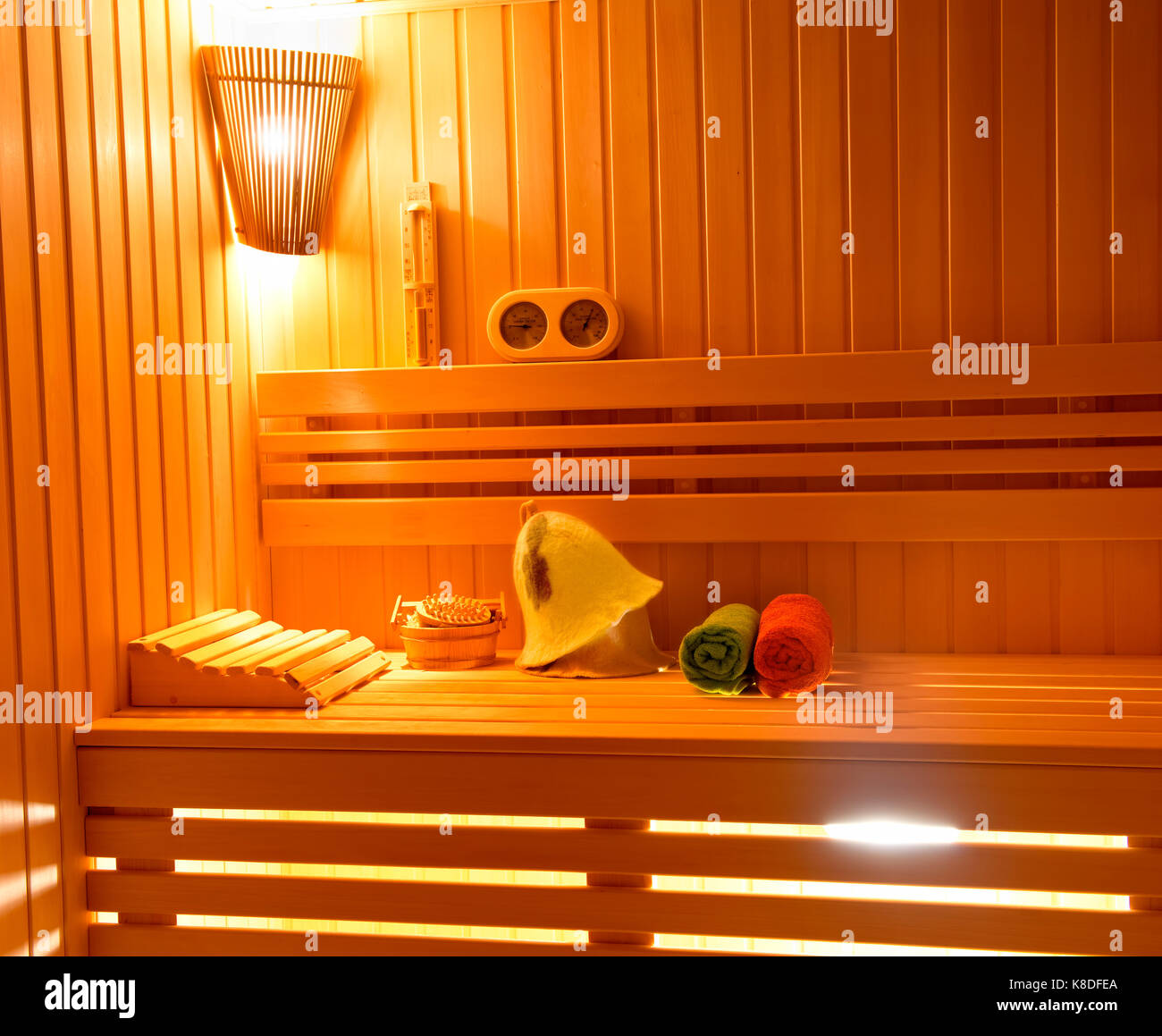 Sauna. Badezimmer Zubehör: Eimer, Löffel schnitzen, Hut, in einer Rolle Handtuch gerollt und eine Vase mit Duftkerzen. Stockfoto