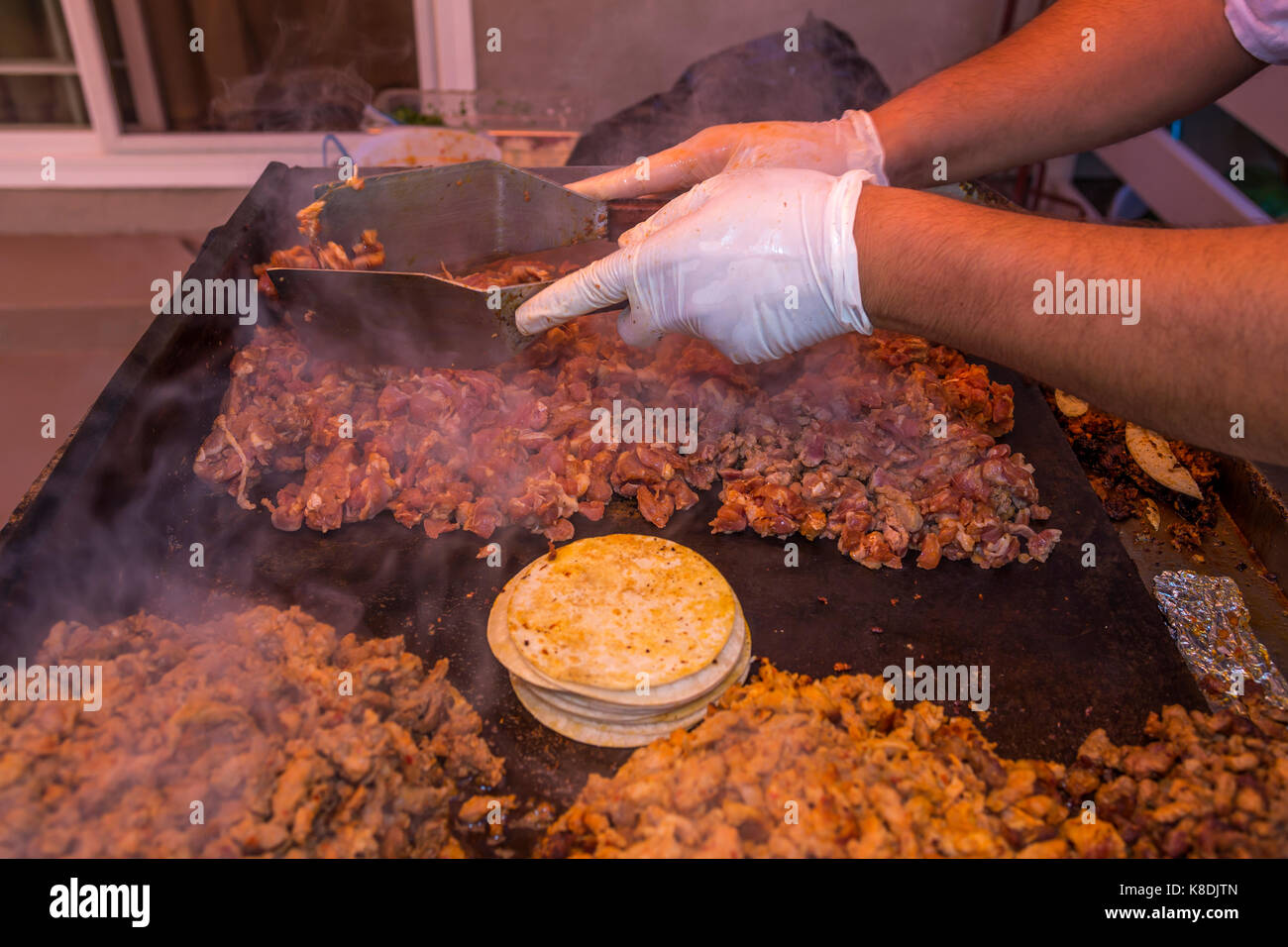 Hispanic Mann, Koch, Kochen auf Flat Top Grill, Grillen, Fleisch, grillen, Fleisch, Bratpfanne, Poolparty, Castro Valley, Alameda County, Kalifornien Stockfoto