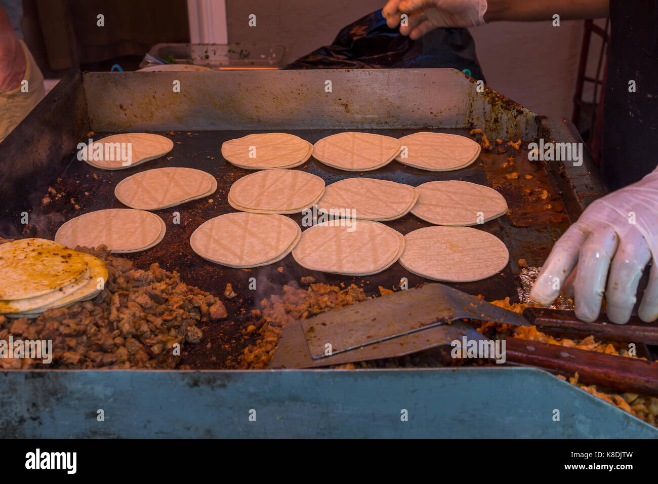 Hispanic Mann, Koch, Kochen auf Flat Top Grill, Grillen, Fleisch, grillen, Fleisch, Bratpfanne, Poolparty, Castro Valley, Alameda County, Kalifornien Stockfoto