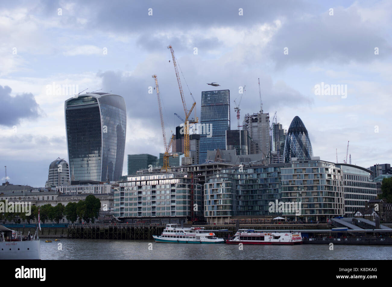 Die Skyline von London an einem bewölkten Tag mit zahlreichen Kräne, Boote, Wolkenkratzer entlang der Themse Stockfoto