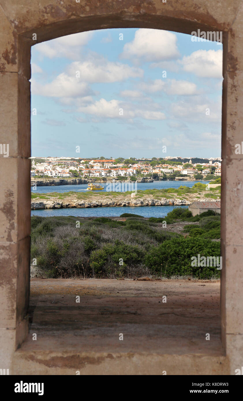 An der Küste Blick auf der Balearen Insel Menorca im Mittelmeer von einem defensiven alte Gewehr Öffnung mit der Stadt Mahon über die Mündung genommen Stockfoto