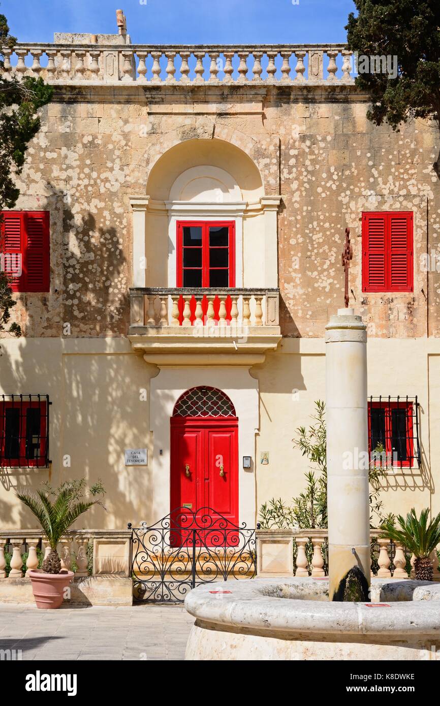Steinbrunnen mit einem Stadthaus an der Rückseite in Bastion Square, Mdina, Malta, Europa. Stockfoto