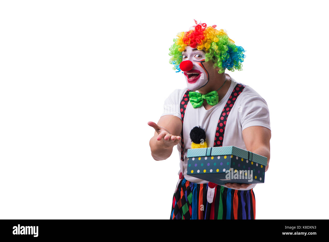 Lustiger Clown mit einer vorliegenden Geschenkbox isoliert auf weißem Hintergrund Stockfoto