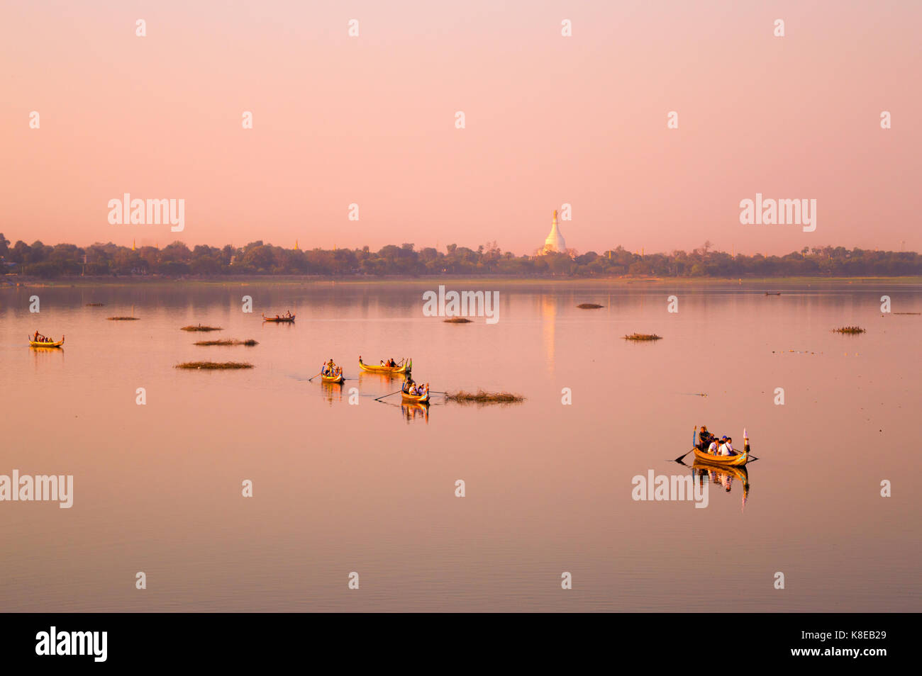 Boote auf dem Taungthaman See bei Sonnenuntergang in Amarapura, Mandalay, Myanmar Stockfoto