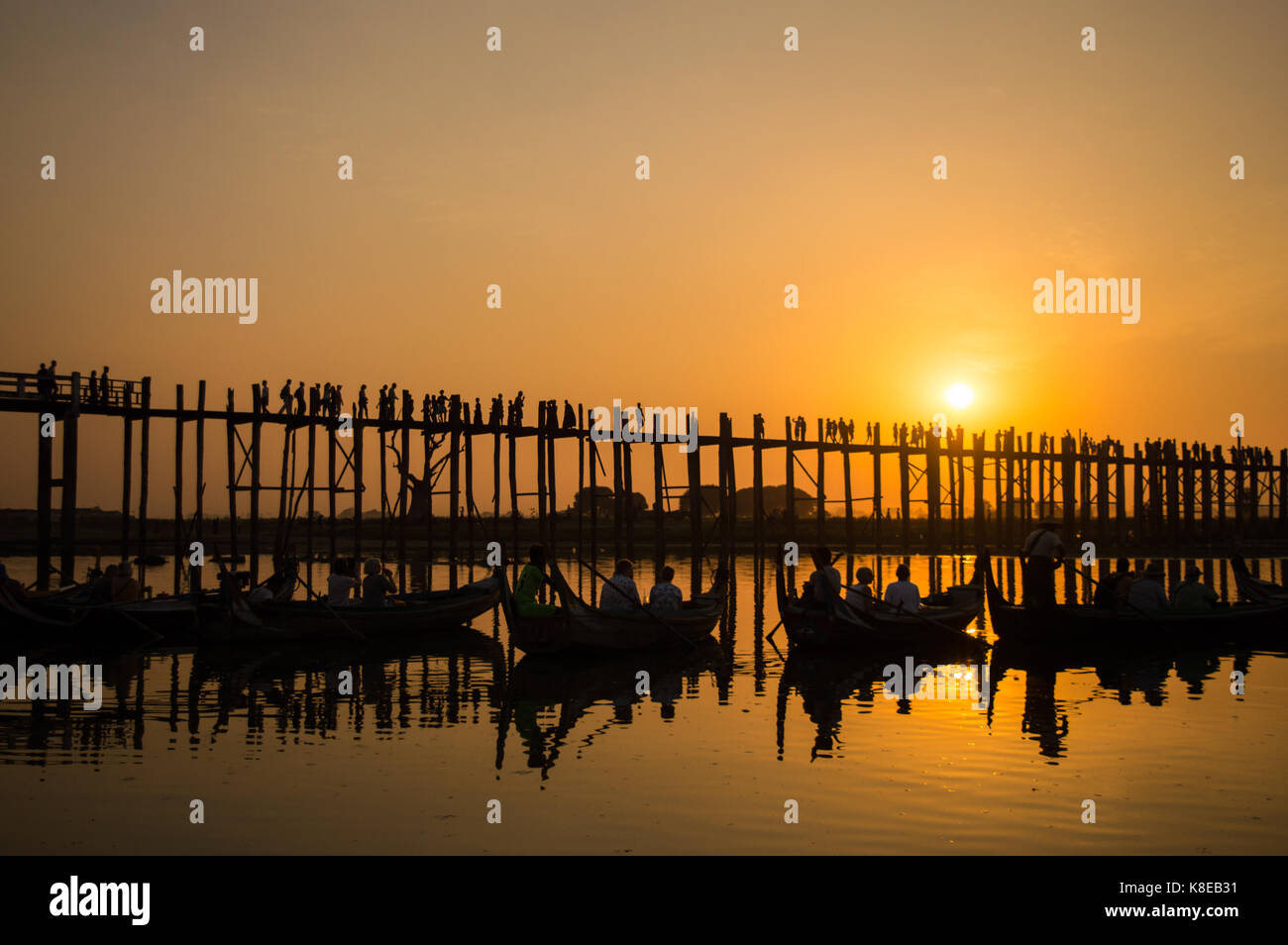 Silhouetten von Touristen in Boote bewundern U Bein Brücke über den Taungthaman-See bei Sonnenuntergang, in Amarapura, Mandalay, Myanmar Stockfoto