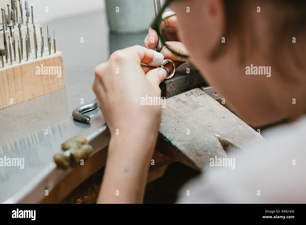 Blick über die Schulter der weiblichen Juwelier und Ring an der Werkbank Stockfoto