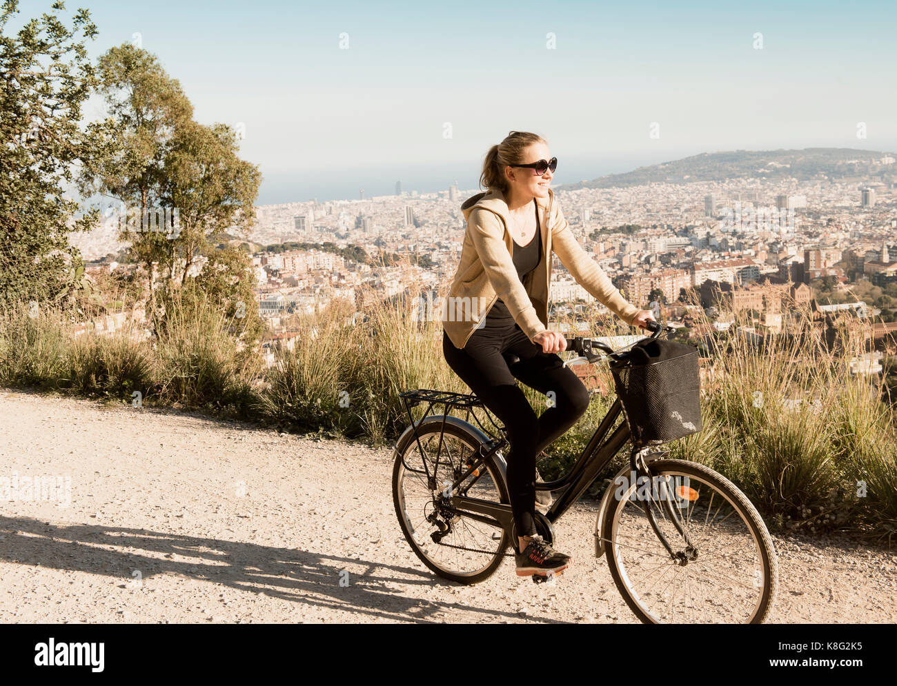 Frau Sightseeing auf dem Fahrrad, Stadt im Hintergrund, Barcelona, Katalonien, Spanien Stockfoto