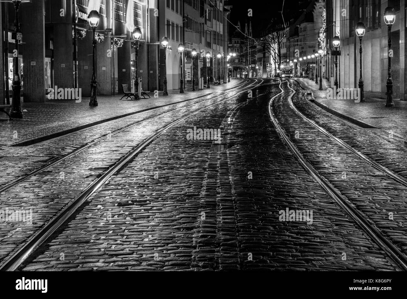 Frühe Morgenaufnahme einer leeren Kaiser-Joseph-Straße in Freiburg. Keine Straßenbahnen, keine Leute, kein Geschäft. Aufgenommen an einem schlechten Wetter november Tag. Stockfoto