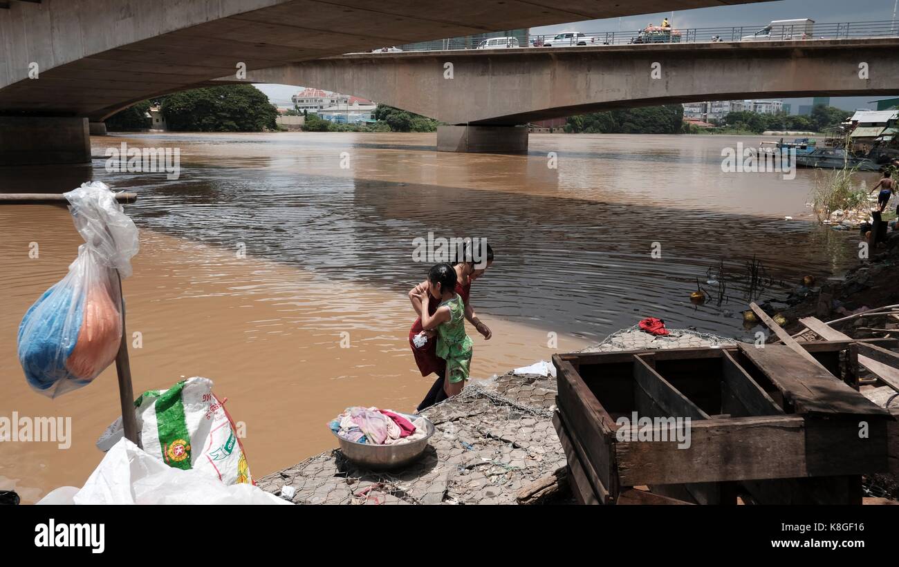 Junge Mädchen waschen Kleidung unter der Monivong-Brücke Phnom Penh Kambodscha das Leben entlang des Bassac-Flusses Vietnamesisch Kambodscha Stockfoto