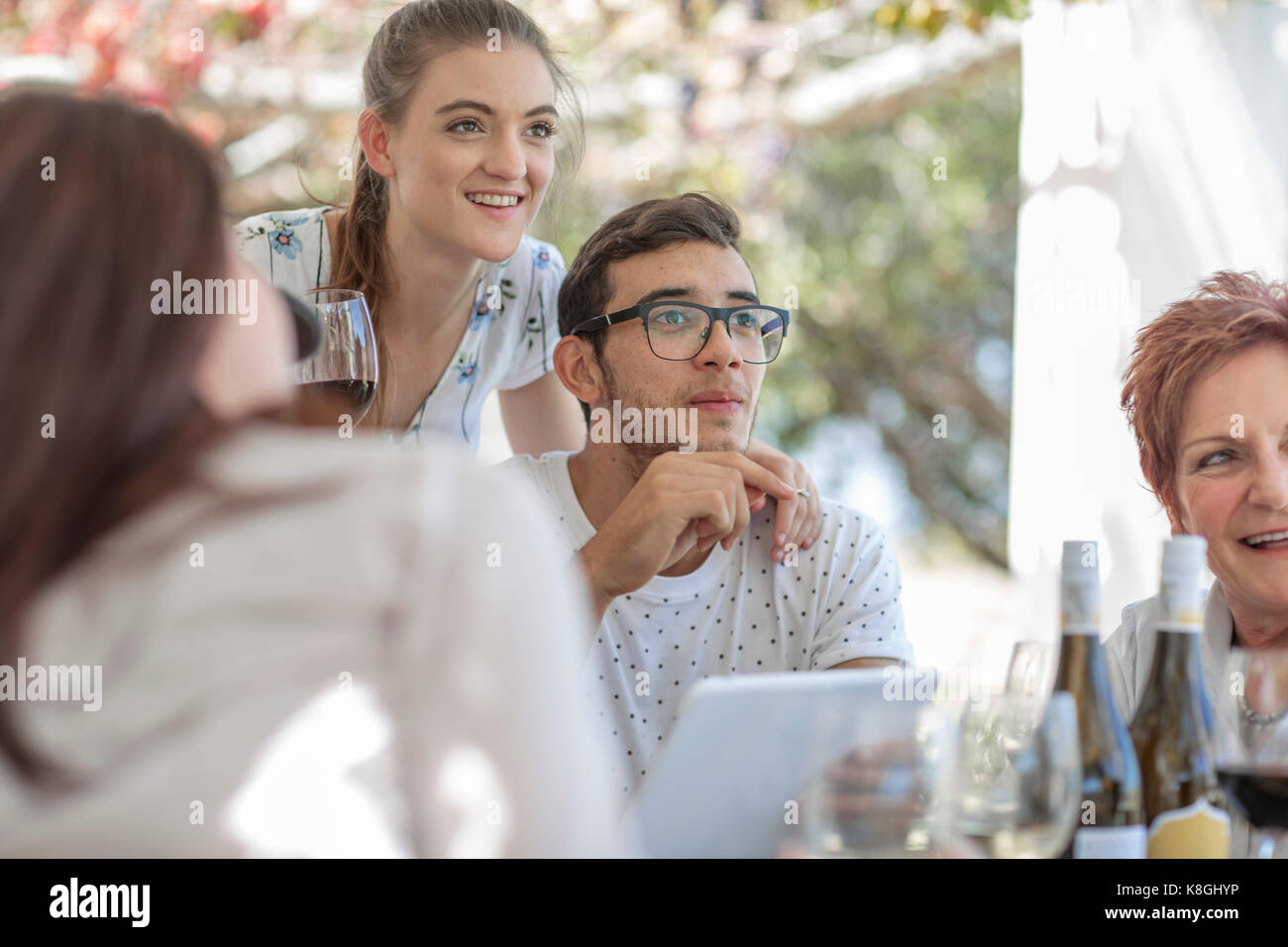 Familie mit Mittagessen im Freien unter Grapevine trellis Stockfoto