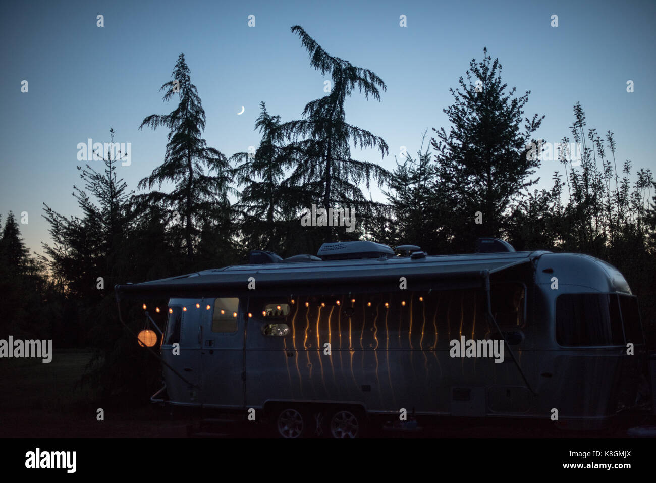 Wohnmobil in ländlicher Umgebung, in der Dämmerung, von Lichterketten beleuchtet Stockfoto