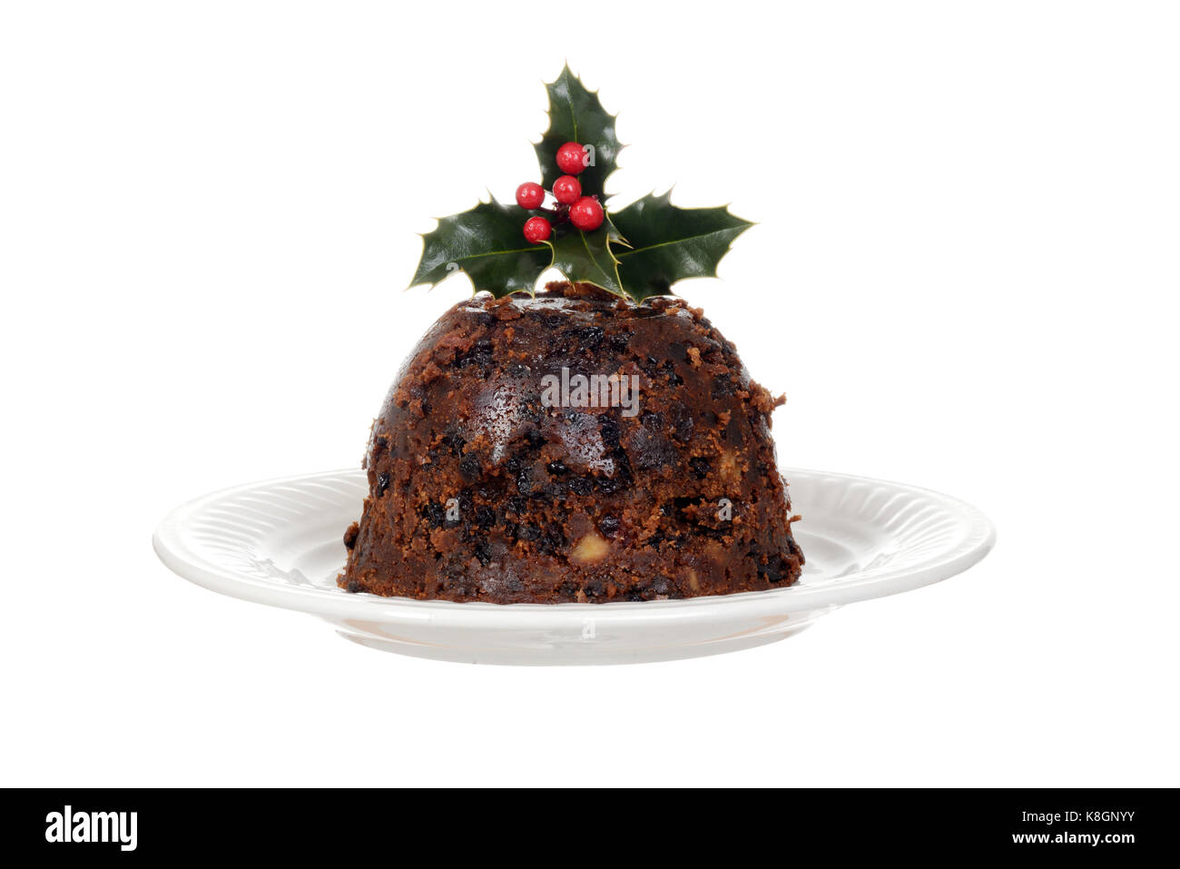 Isolierte Weihnachten brandy Pudding auf Platte mit Holly Stockfoto