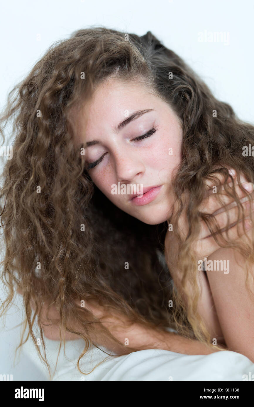 Junges Mädchen lag auf einem Bett mit geschlossenen Augen. Stockfoto