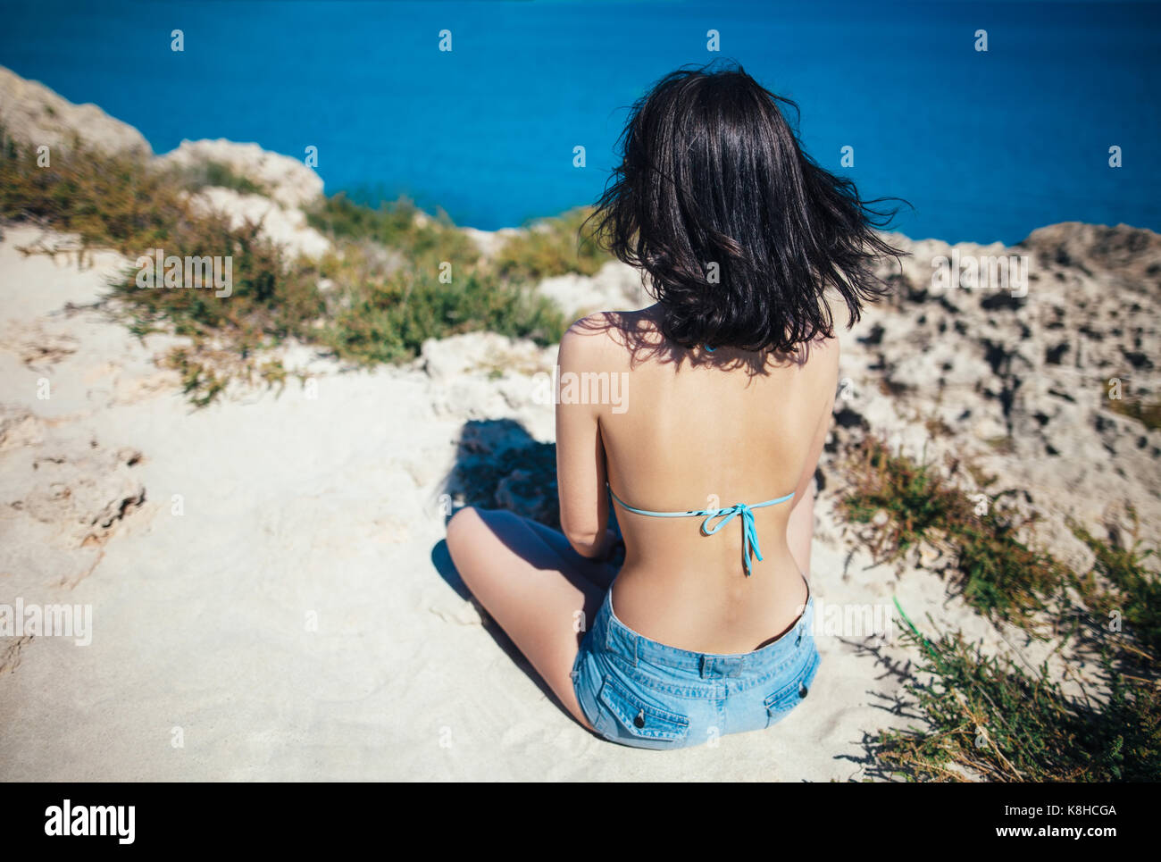 Rückansicht der jungen Frau mit wunderschönem Meerblick in Zypern Stockfoto