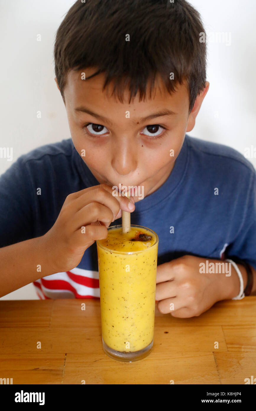 10-jährige europäische Junge trinkt ein Smoothie. Kambodscha. Stockfoto