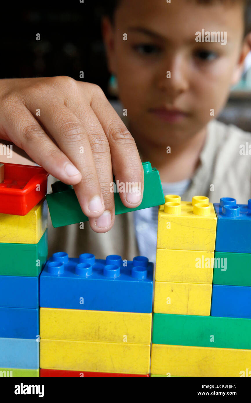 10-jähriger Junge beim Spielen mit Lego. Thailand. Stockfoto
