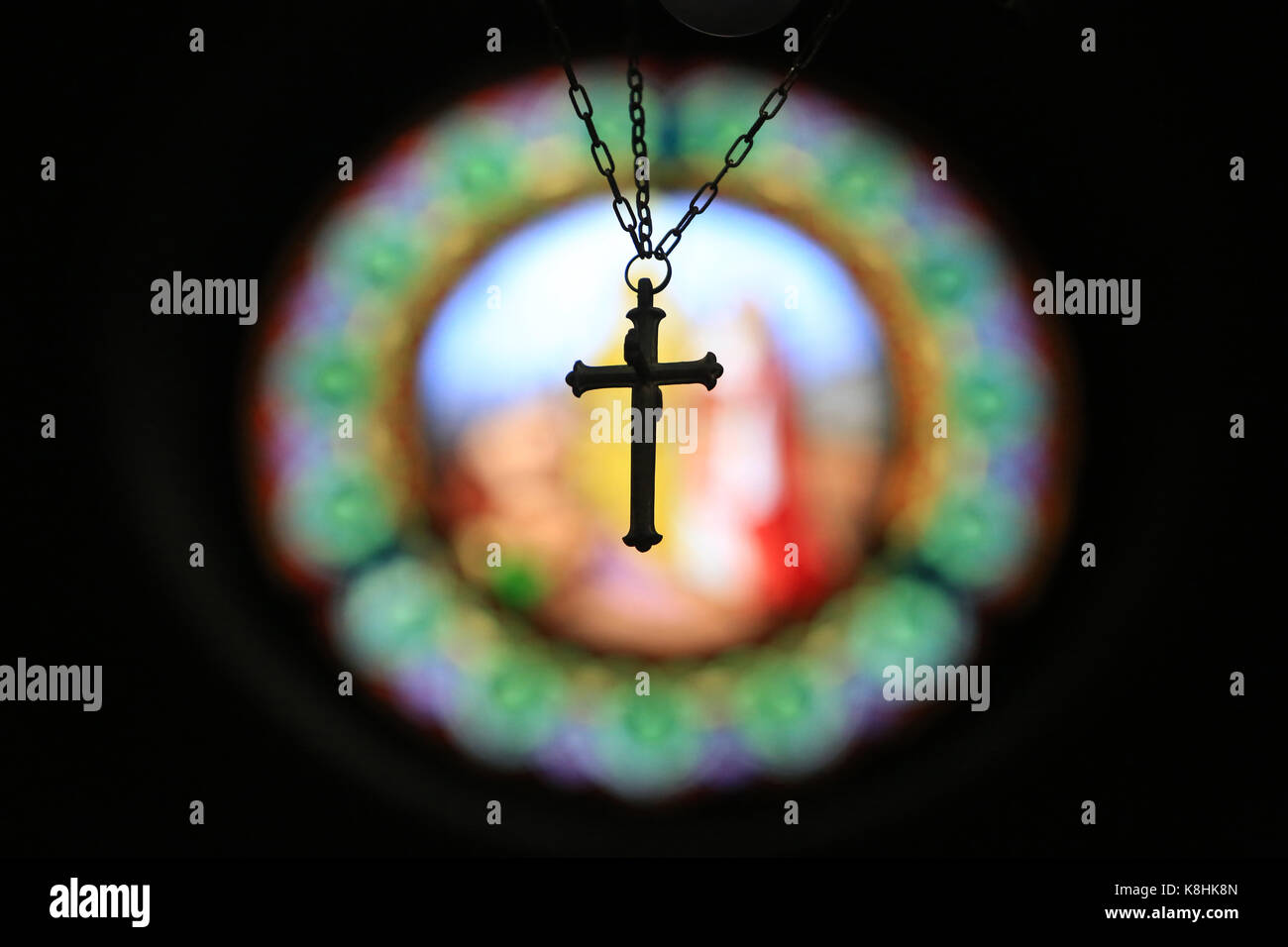 Kruzifix an das Licht auf einem Glasfenster aufgehängt. kirche st. Clodoald. saint-Wolke. Stockfoto