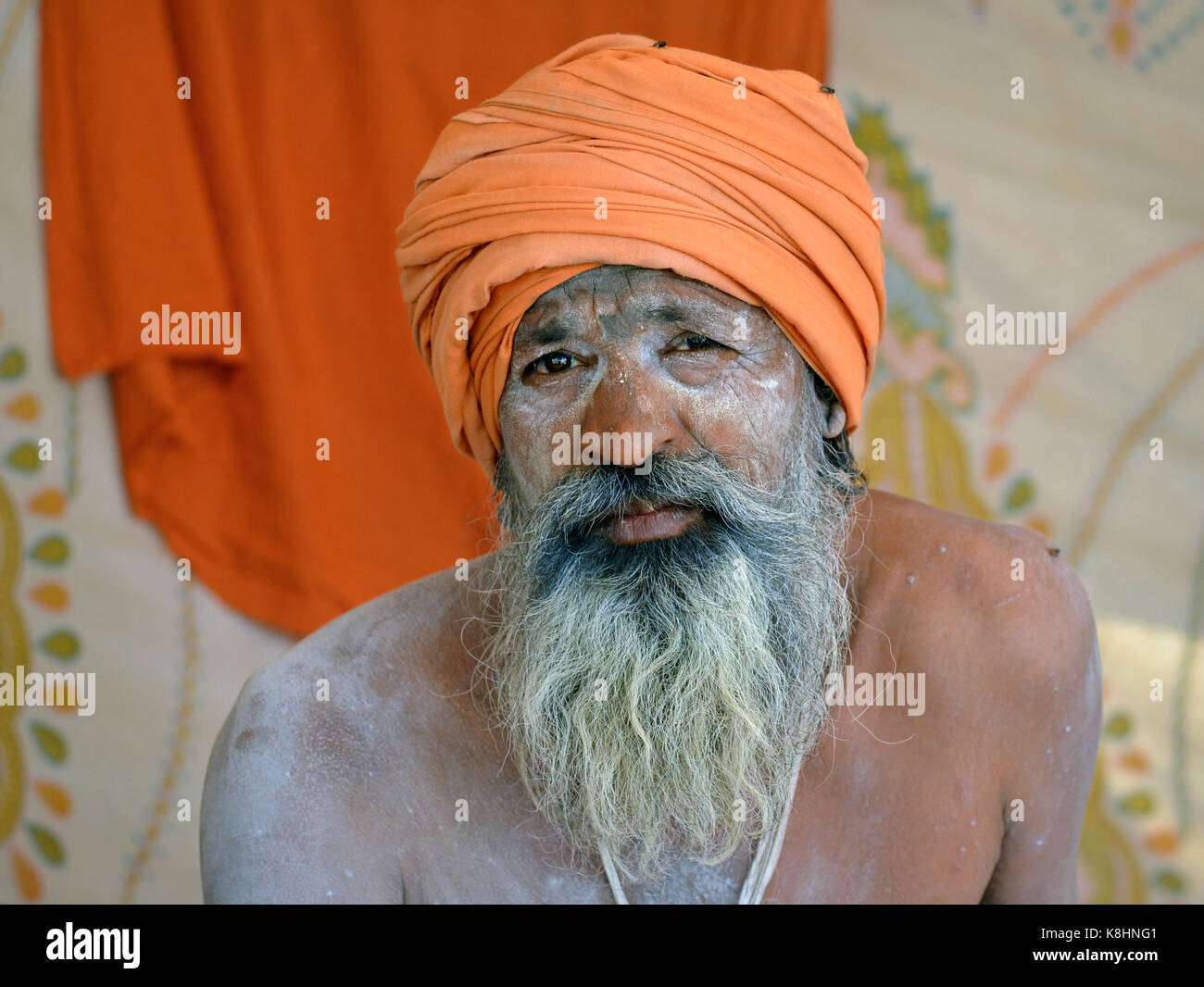 Alte indisch-hinduistischen Sadhu mit orangefarbenen Turban und Heilige weiße Asche (vibhuti) alle über sein Gesicht und Bart Stockfoto