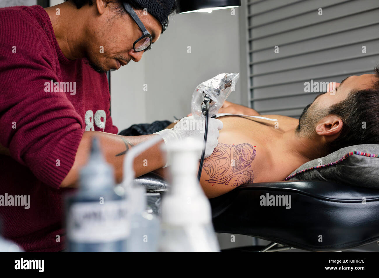 Tattoo artist tattooing Schulter des Menschen Stockfoto