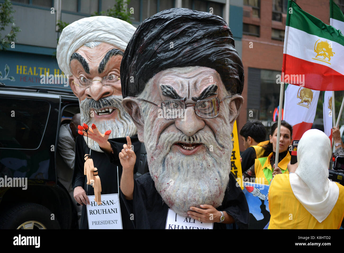 Menschen, die so tut, als der iranische Präsident Hassan Ruhani und Ali Hosseini Khamenei während der Generalversammlung der Vereinten Nationen in Manhattan. Stockfoto
