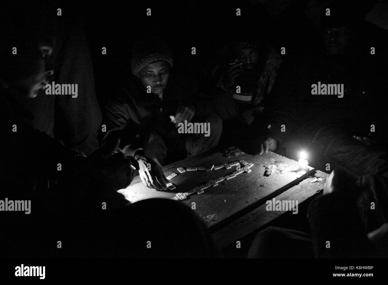 Sudanesischen Asylbewerber spielen Domino bei Kerzenlicht in einem illegalen, verlassenen Lagerhalle namens 'Afrika Haus" in Calais, Frankreich Am 26. Februar 2010. Stockfoto