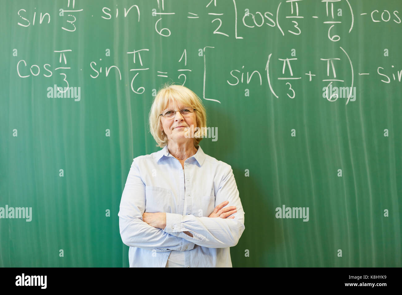 Ältere Frau als Mathe Lehrer oder Dozent vor der Tafel Stockfoto