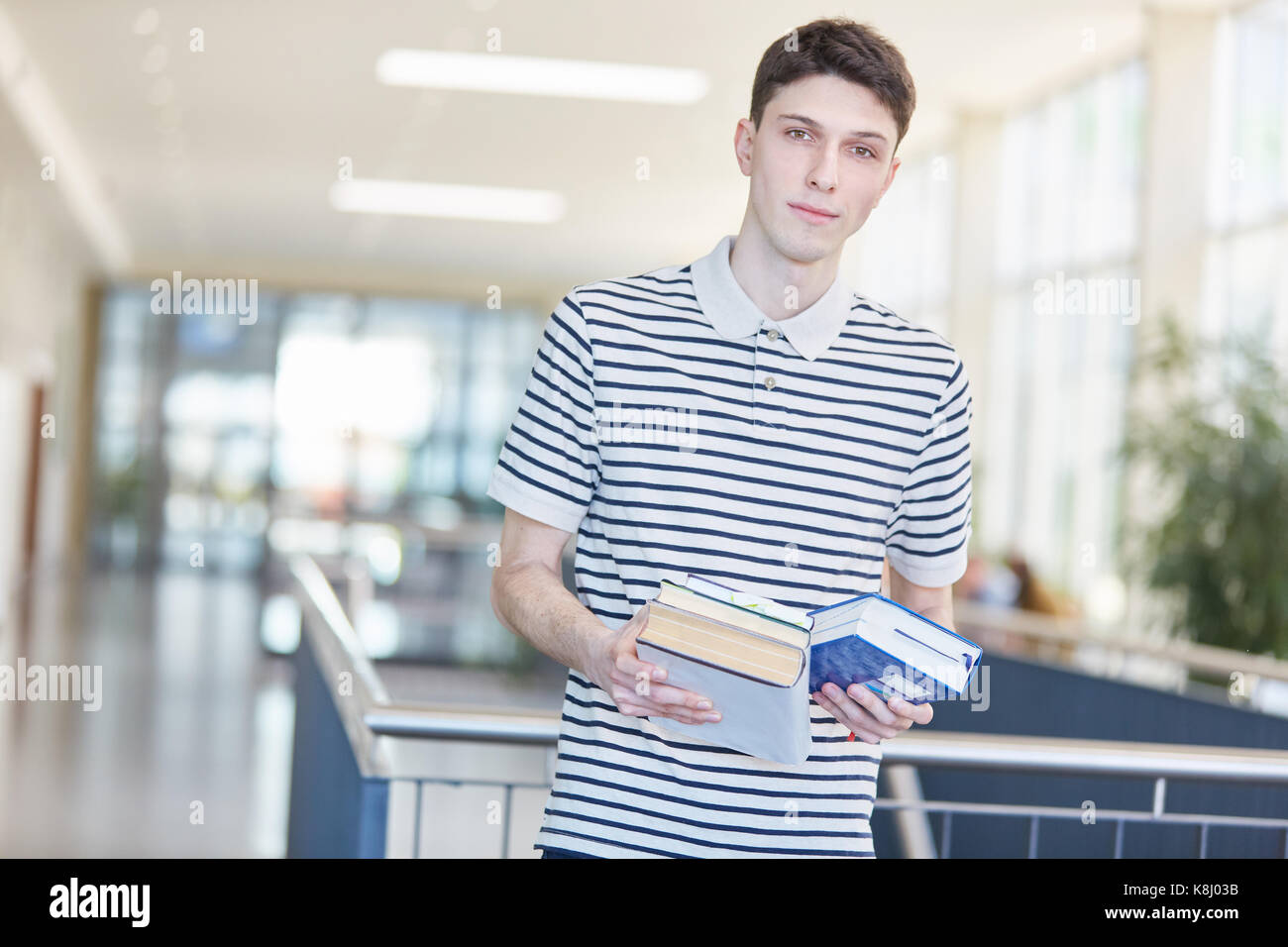 Student oder Schüler in der Schule hält Bücher für sein Studium Stockfoto