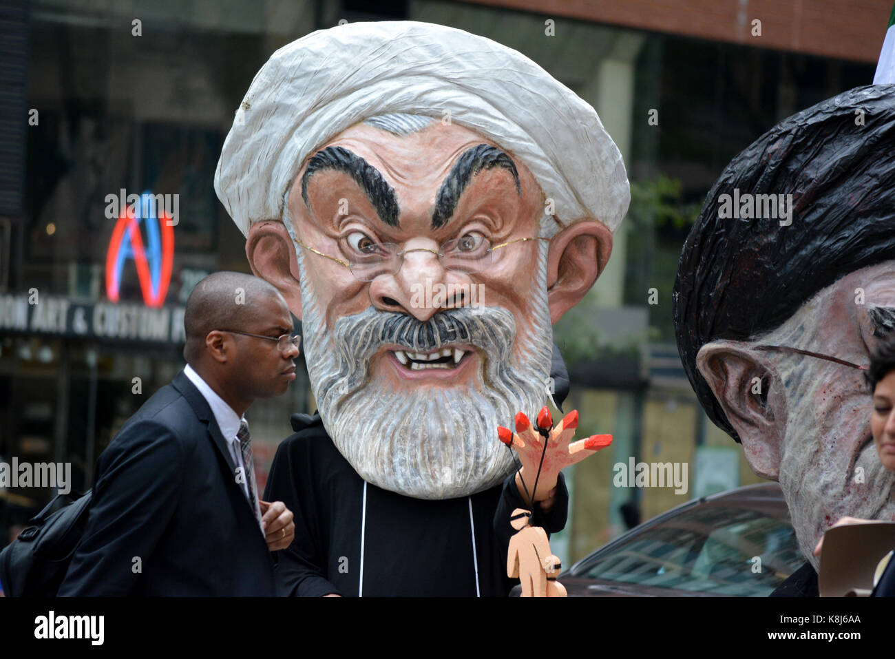 Menschen, die so tut, als der iranische Präsident Hassan Ruhani und Ali Hosseini Khamenei während der Generalversammlung der Vereinten Nationen in Manhattan. Stockfoto