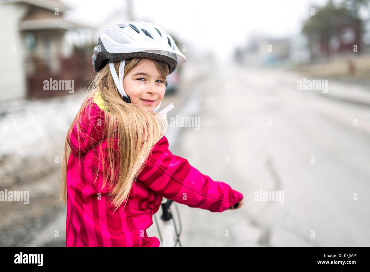 Kleine Mädchen mit dem Fahrrad in einer Stadt Stockfoto