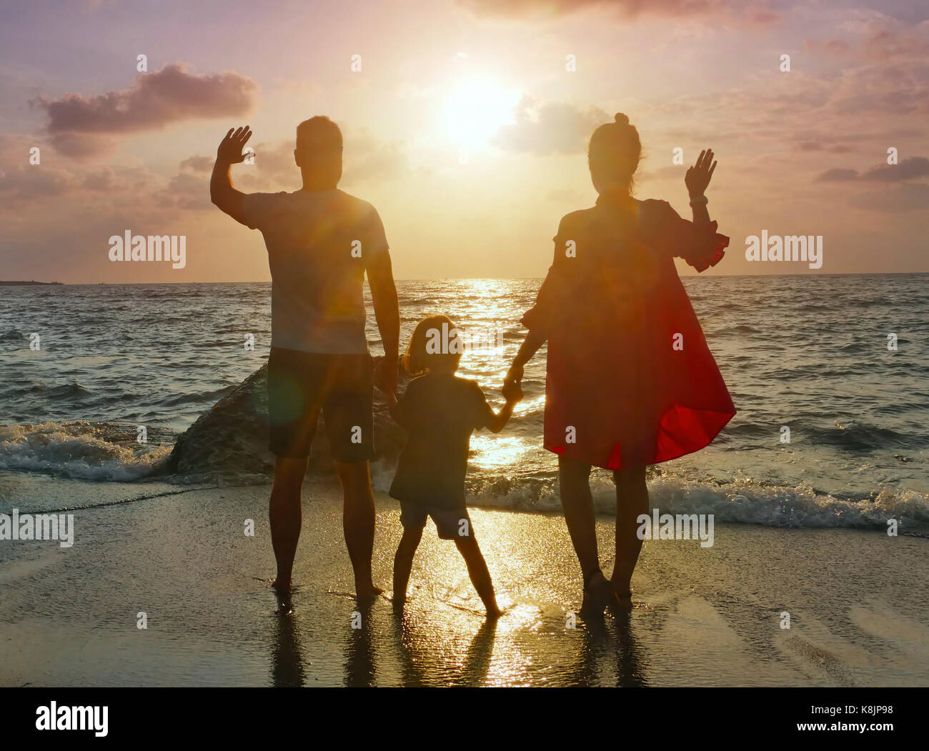 Eine junge Familie verbringt Sommer Abend bei Sonnenuntergang am Strand Stockfoto