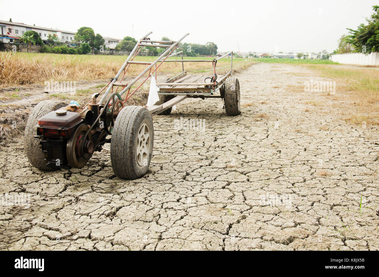 Schäden, die alten Traktor und Anhänger Anschlag auf Reisfeld warten Frühling auf Wüste Land, weil Dürre Katastrophe im Hinterland von Thailand Stockfoto