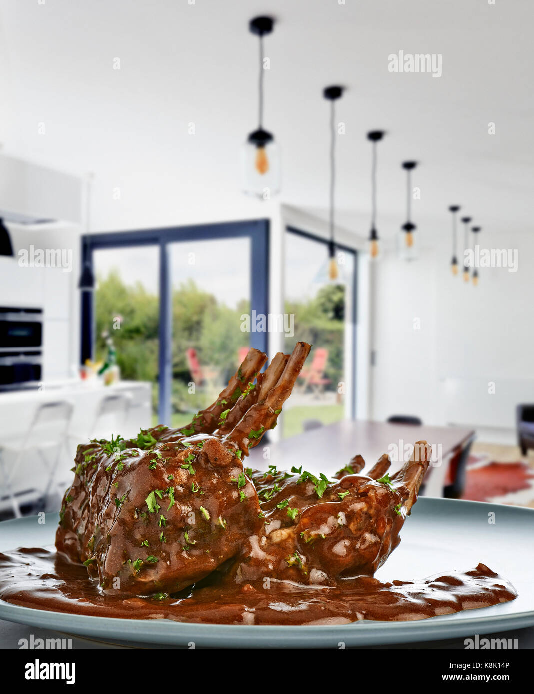 Nahaufnahme der Saft gebratenen Lammkoteletts in ein modernes luxuriöses Wohnzimmer und Küche Stockfoto