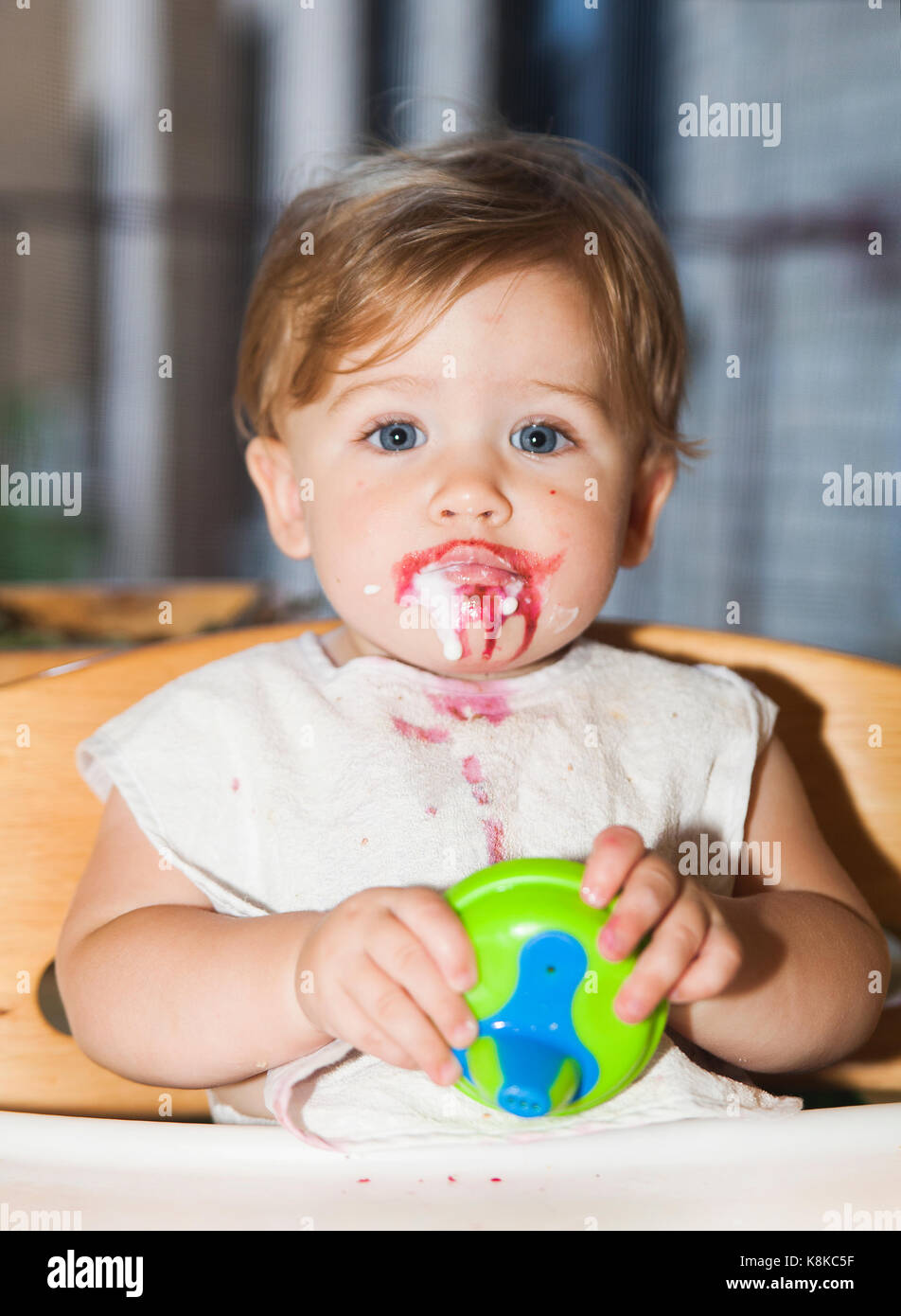 Gerne unordentlich Baby mit Essen auf ihrem Gesicht nach dem essen Dessert Stockfoto