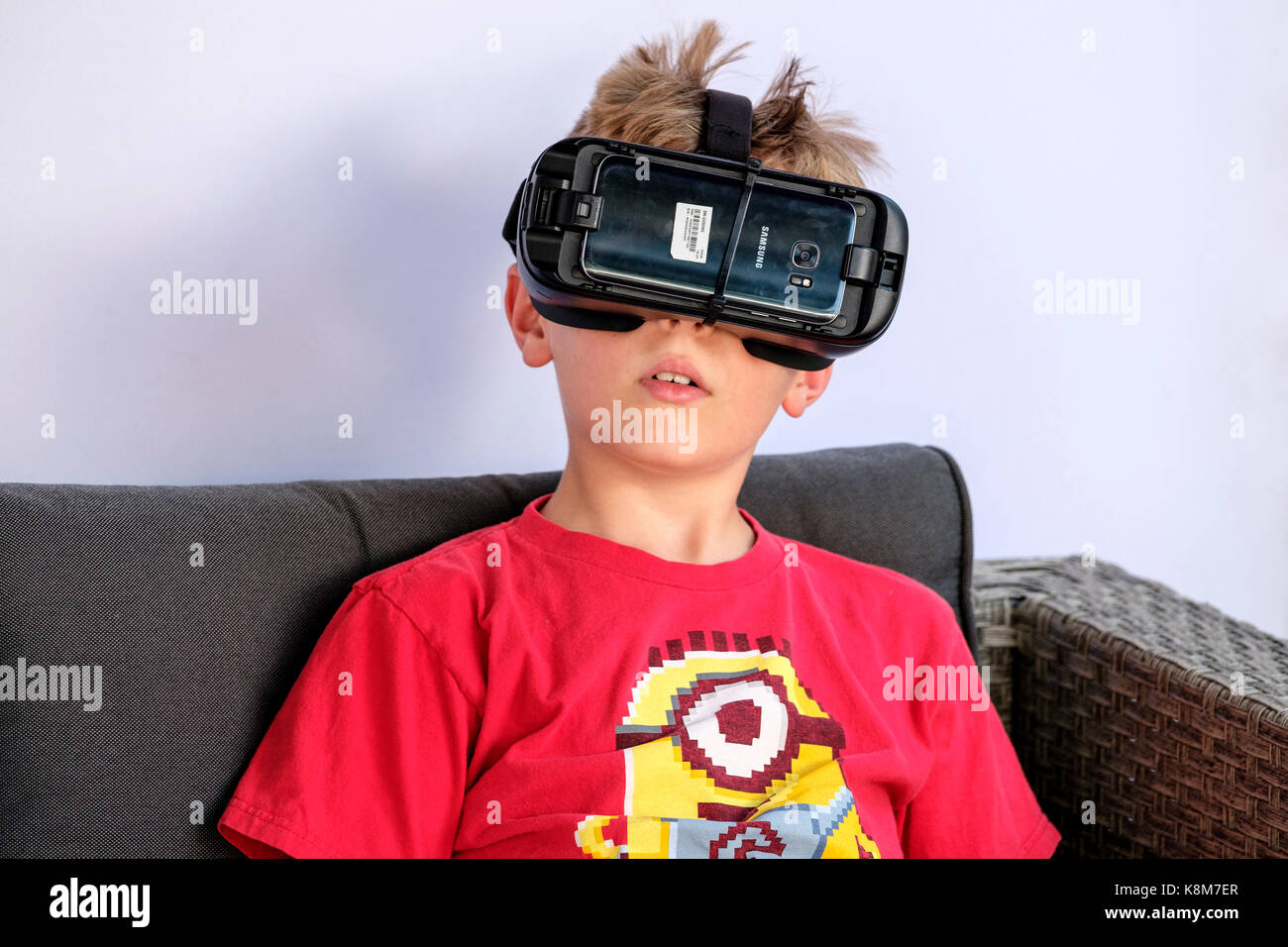 Nahaufnahme eines jungen Jungen mit Oculus Gear VR-Headset, Virtual Reality (VR)-Ausrüstung mit Samsung-Handy. Stockfoto
