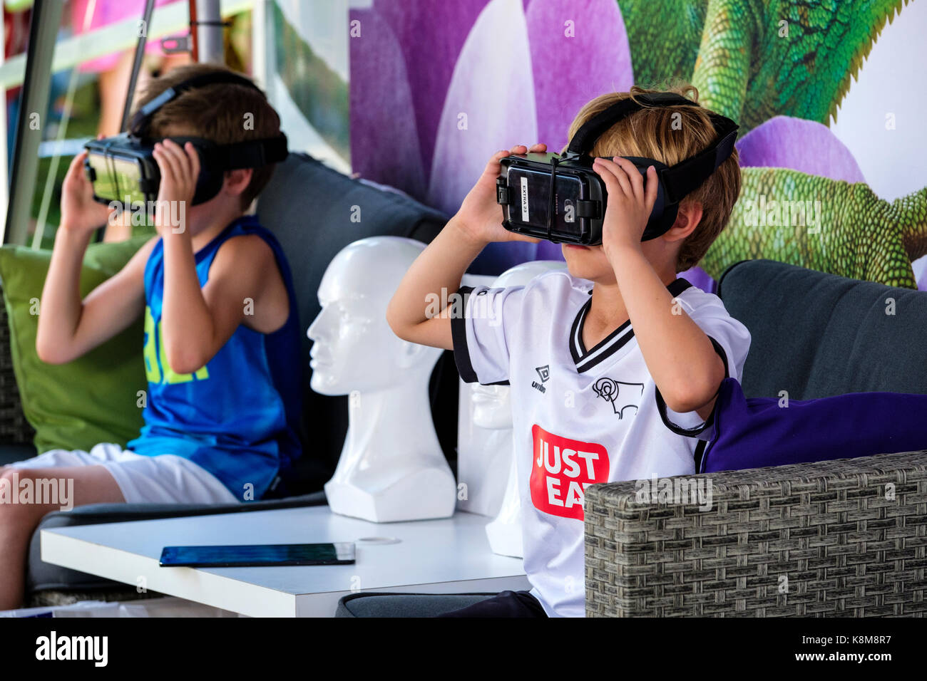 Junge Jungen mit Oculus Gear VR-Headset, Metaverse Virtual Reality (VR)-Ausrüstung mit Samsung-Handy an einem Telus Mobility-Stand. Stockfoto
