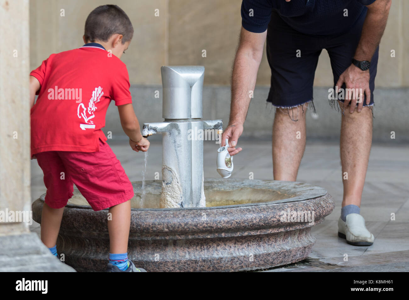 Karlsbad, Tschechische Republik - 15. August 2017: Kinder und Erwachsene füllen Sie die Schale an der öffentlichen Brunnen mit Thermalwasser im historischen Stadtzentrum Stockfoto