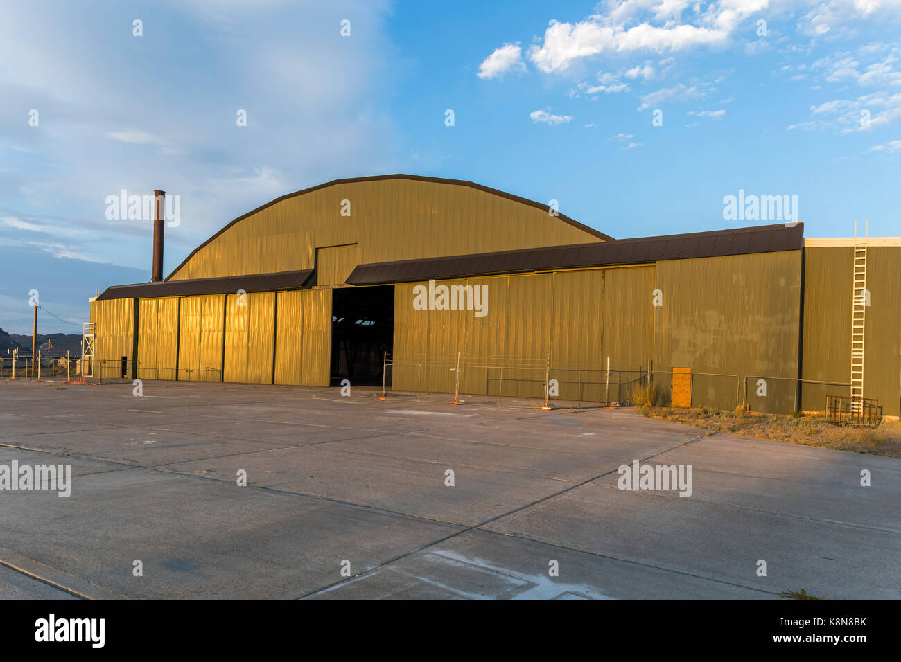 Das Licht der untergehenden Sonne leuchtet auf der Vorderseite der Enola Gay Hangar am Historischen Wendover Airfield in Wendover, Utah, USA. Stockfoto