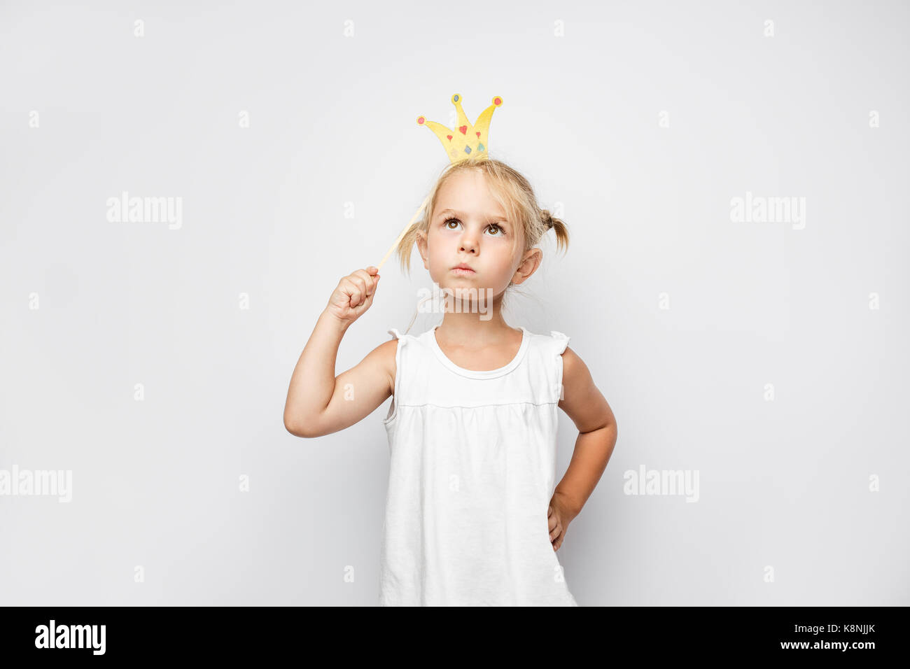 Schöne Mädchen mit Papier Krone posiert auf weißem backgroun Stockfoto