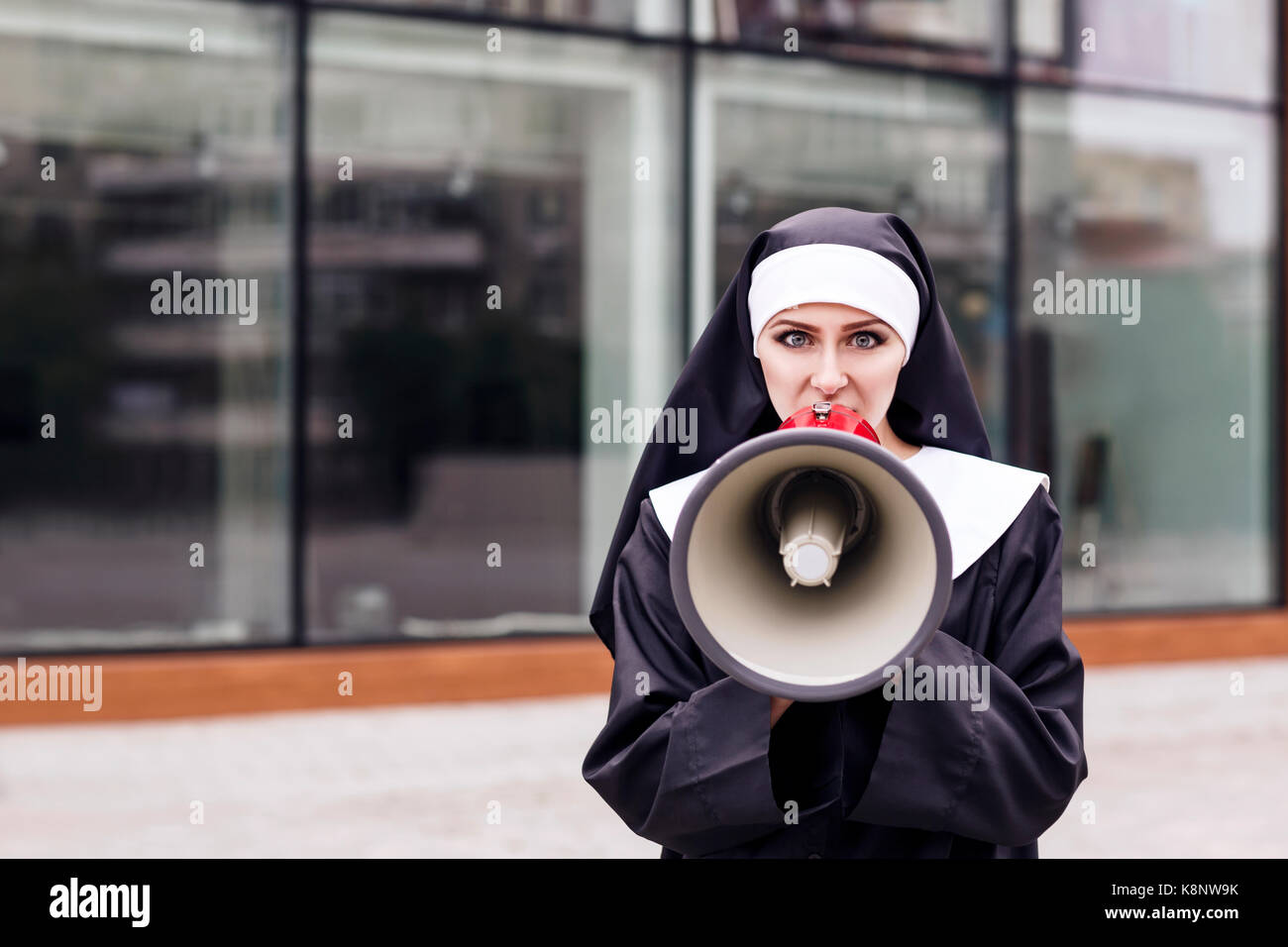 Überrascht Nonne sprechen, draußen zu Megaphon. Stockfoto