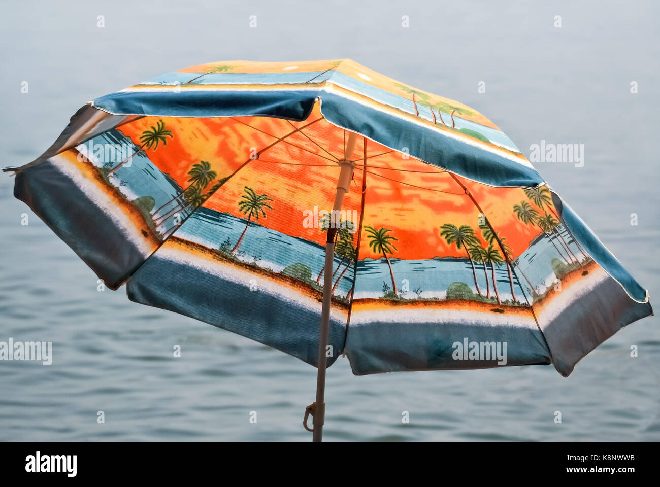 Nahaufnahme von einem bunten Sonnenschirm am Strand Stockfoto