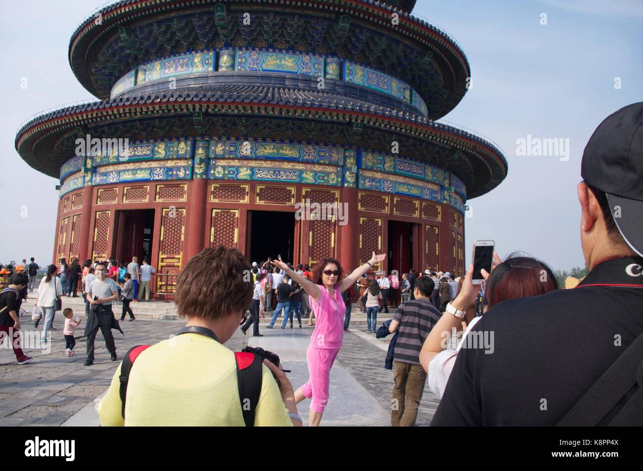 Eine Frau posiert für ein Foto vor dem Himmelstempel in Peking, ein beliebter Ort für Touristen sowohl für chinesische und ausländische Urlauber. Stockfoto