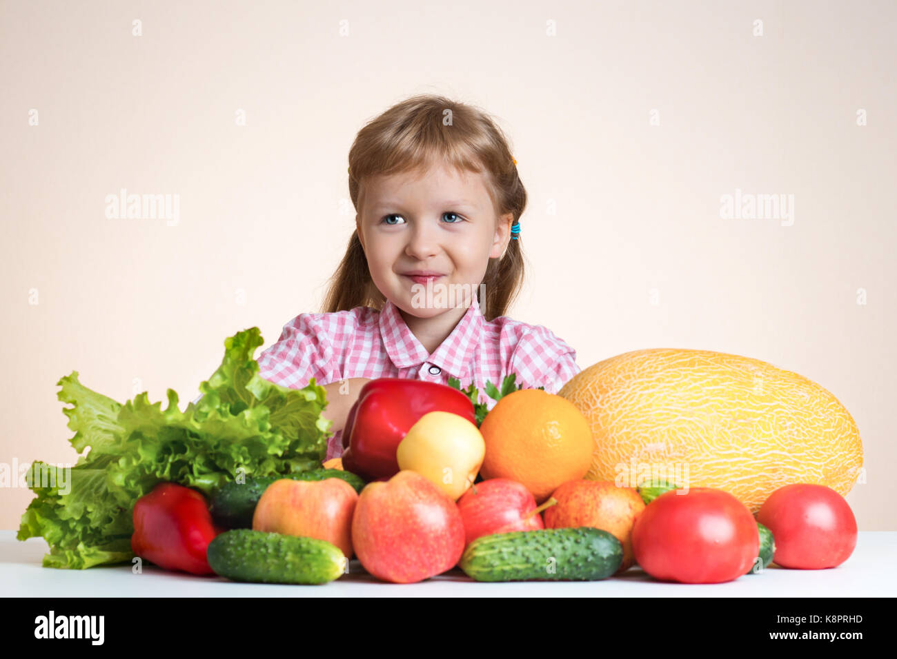 Gerne kleine Mädchen und viel Obst und Gemüse. Konzept der gesunden Ernährung. Stockfoto
